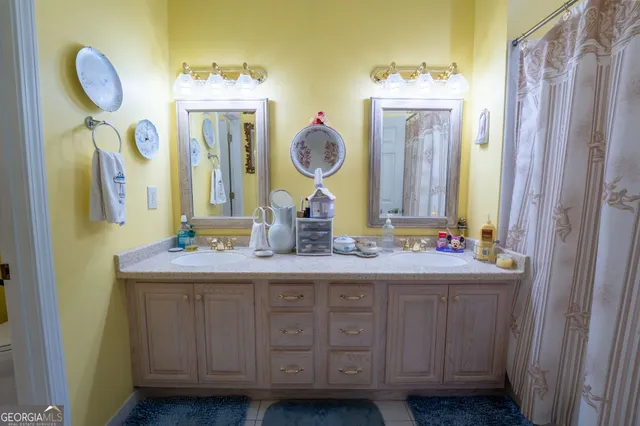 a bathroom with a granite countertop sink a toilet a mirror and tub