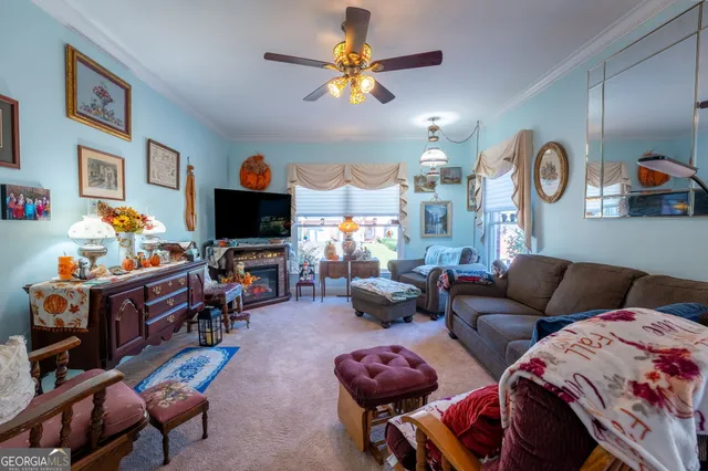 a living room with furniture kitchen view and a flat screen tv
