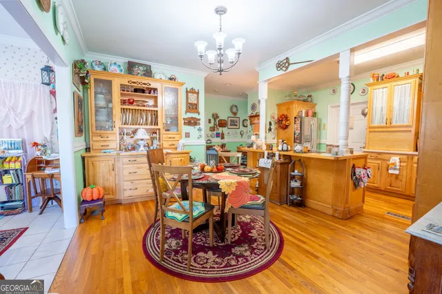 a view of a dining room with furniture a chandelier and wooden floor