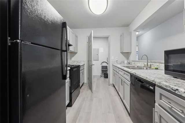 a kitchen with stainless steel appliances granite countertop a refrigerator and a sink