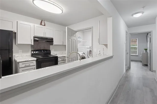 a kitchen with granite countertop white cabinets and stainless steel appliances