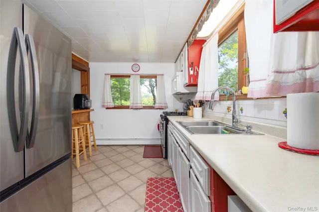 a kitchen with a sink a stove a refrigerator and a window