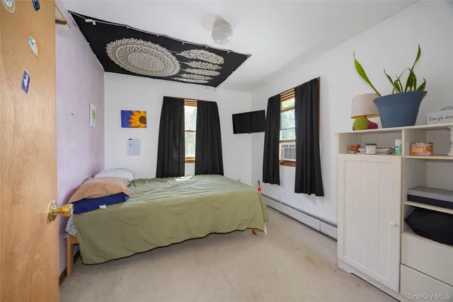 a bedroom with a bed and a refrigerator