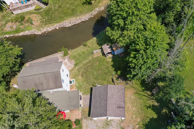 an aerial view of a house with a yard and lake view