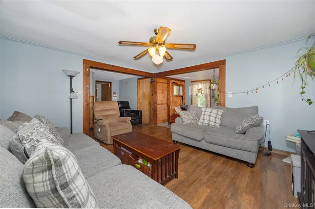 a living room with furniture two window and a chandelier