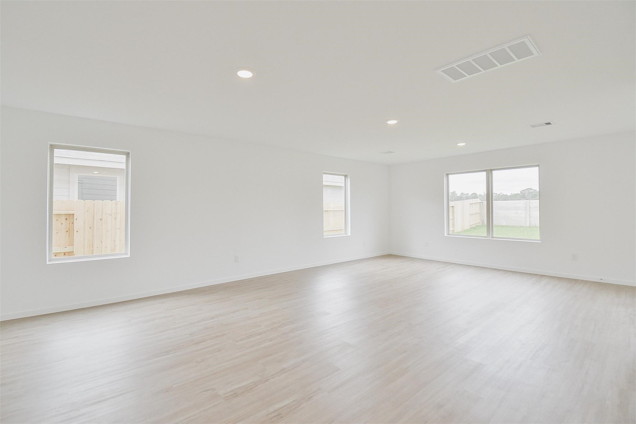 18566 Cepagatti Drive New Caney, TX 77357 - Photo 16 of 35 an empty room with wooden floor and windows