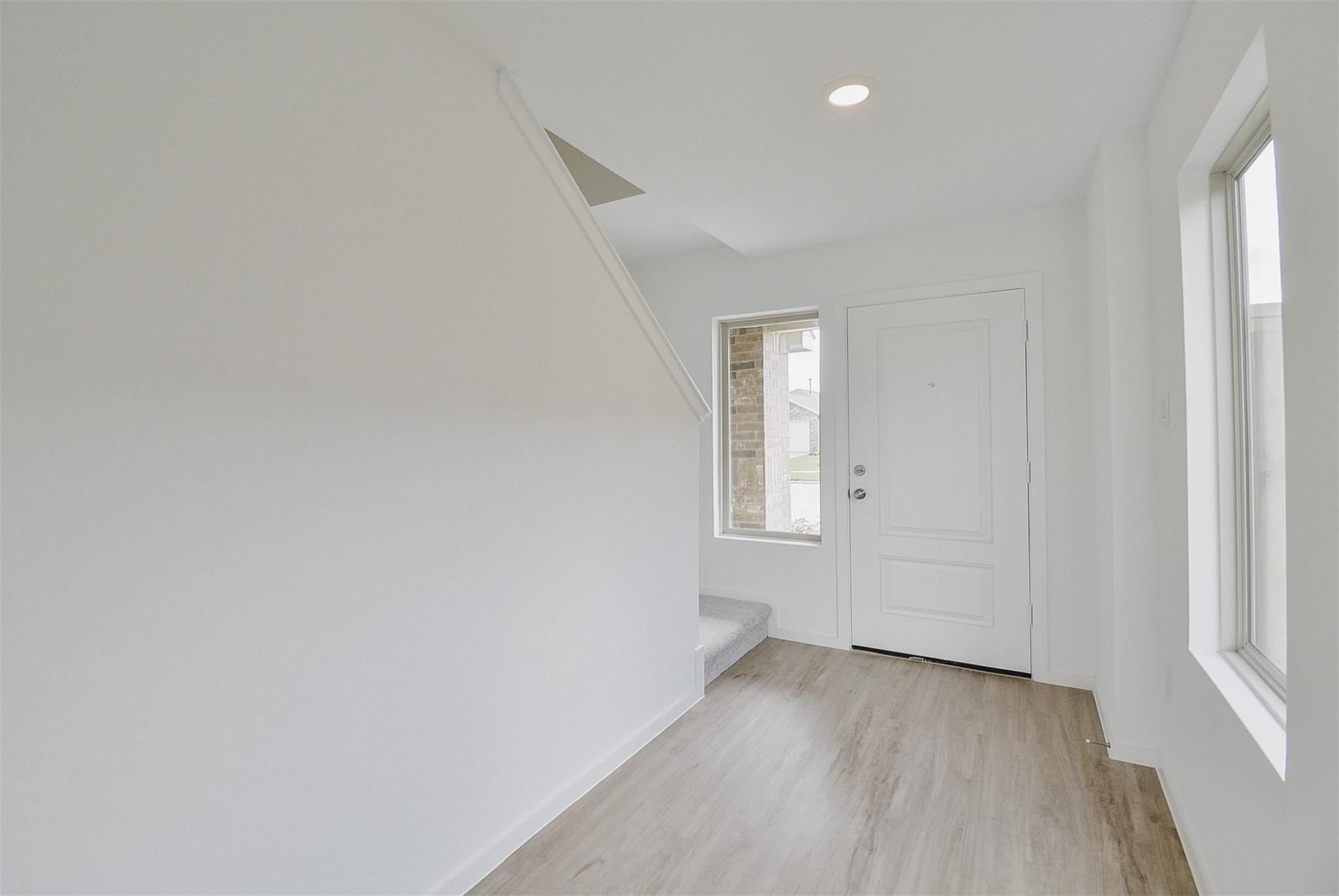 18566 Cepagatti Drive New Caney, TX 77357 - Photo 4 of 35 an empty room with wooden floor and windows