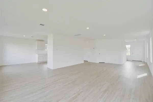 a view of empty room with wooden floor and windows