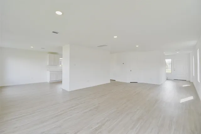 a view of empty room with wooden floor and windows
