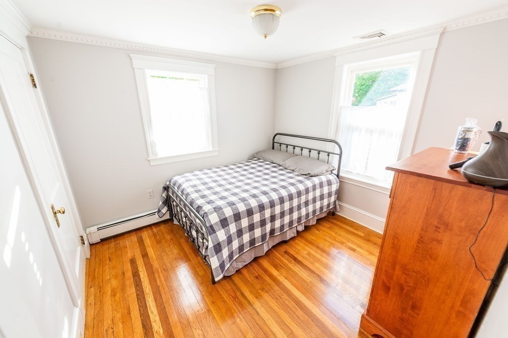 71 Waldeck Road Milton, MA 02186 - Photo 19 of 27 a bedroom with a bed and wooden floor