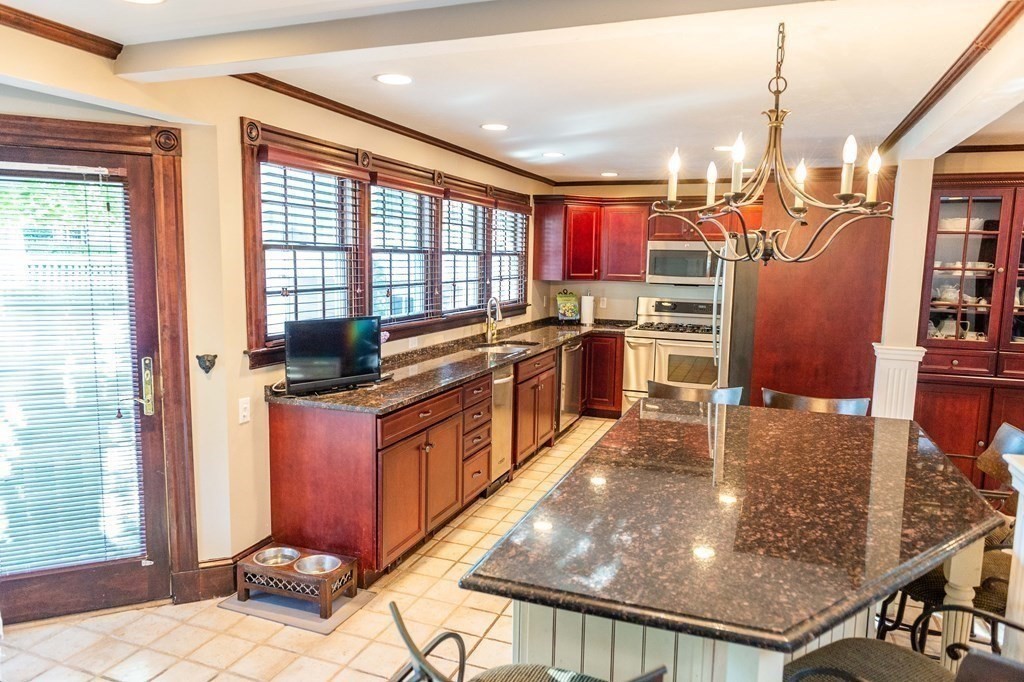 71 Waldeck Road Milton, MA 02186 - Photo 6 of 27 a kitchen with stainless steel appliances granite countertop a stove top oven a sink dishwasher and a refrigerator with wooden floor
