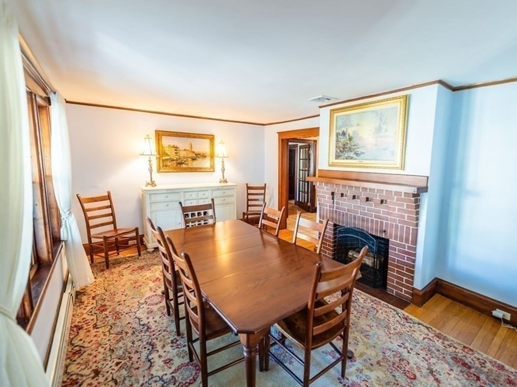 71 Waldeck Road Milton, MA 02186 - Photo 8 of 27 a dining room with furniture and a fireplace