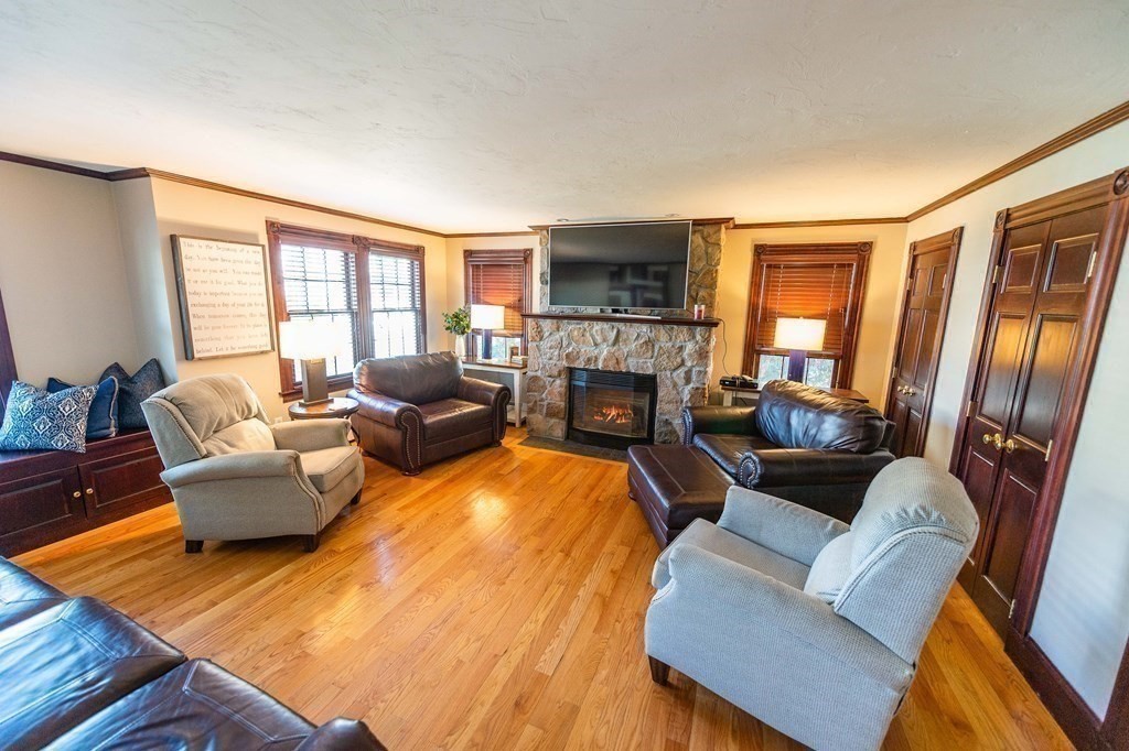 71 Waldeck Road Milton, MA 02186 - Photo 10 of 27 a living room with fireplace furniture and a flat screen tv