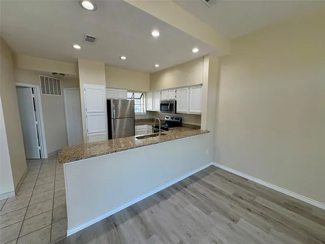 a large kitchen with a refrigerator and a stove top oven