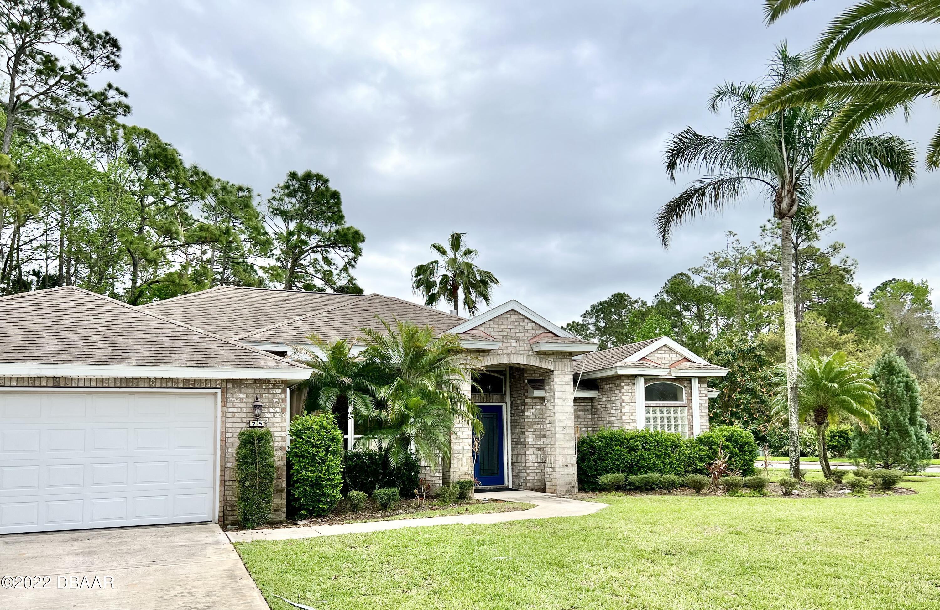 a front view of a house with a garden