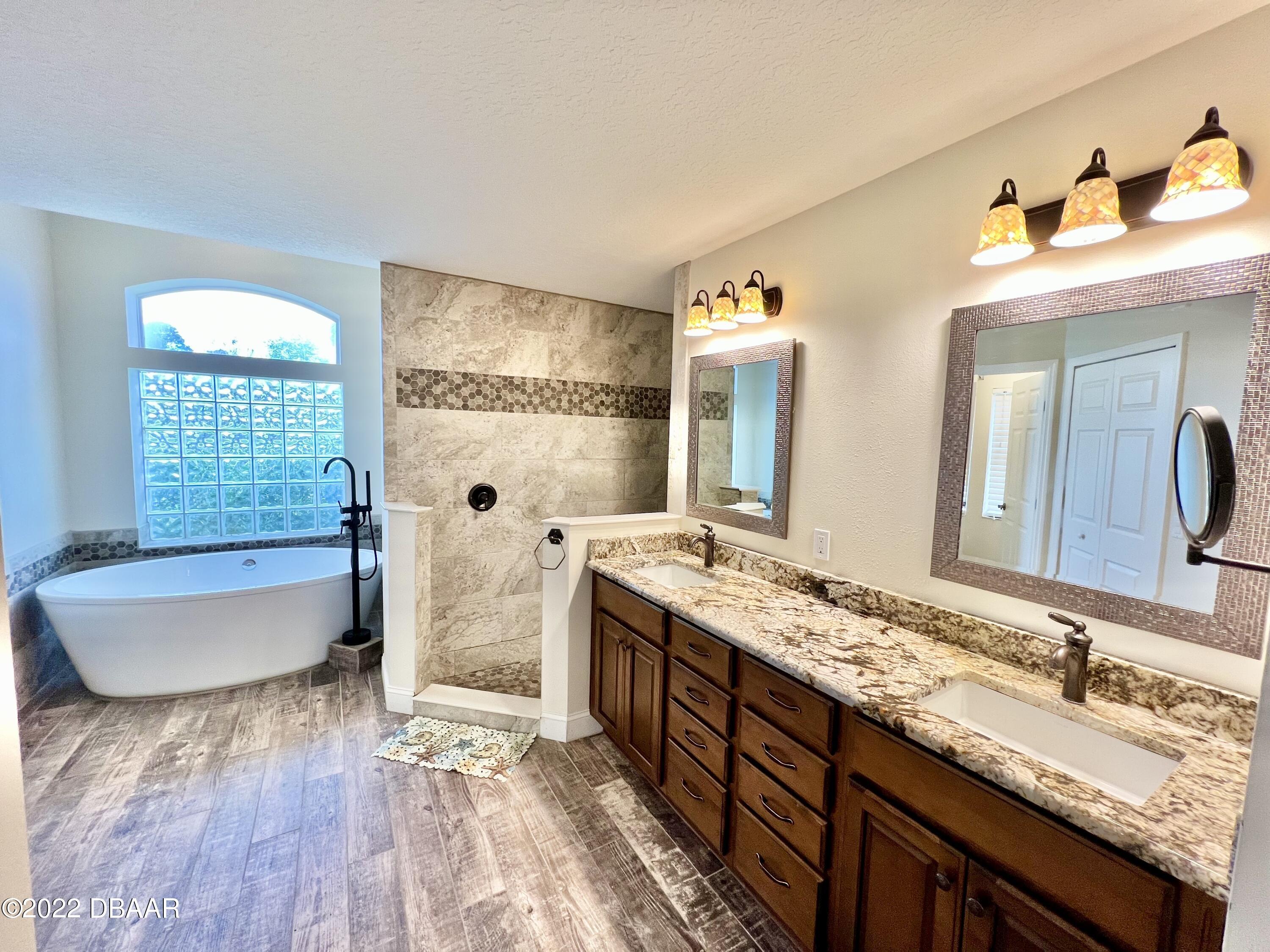 75 Creek Bluff Way Ormond Beach, FL 32174 - Photo 11 of 20 a bathroom with a granite countertop sink mirror and bathtub
