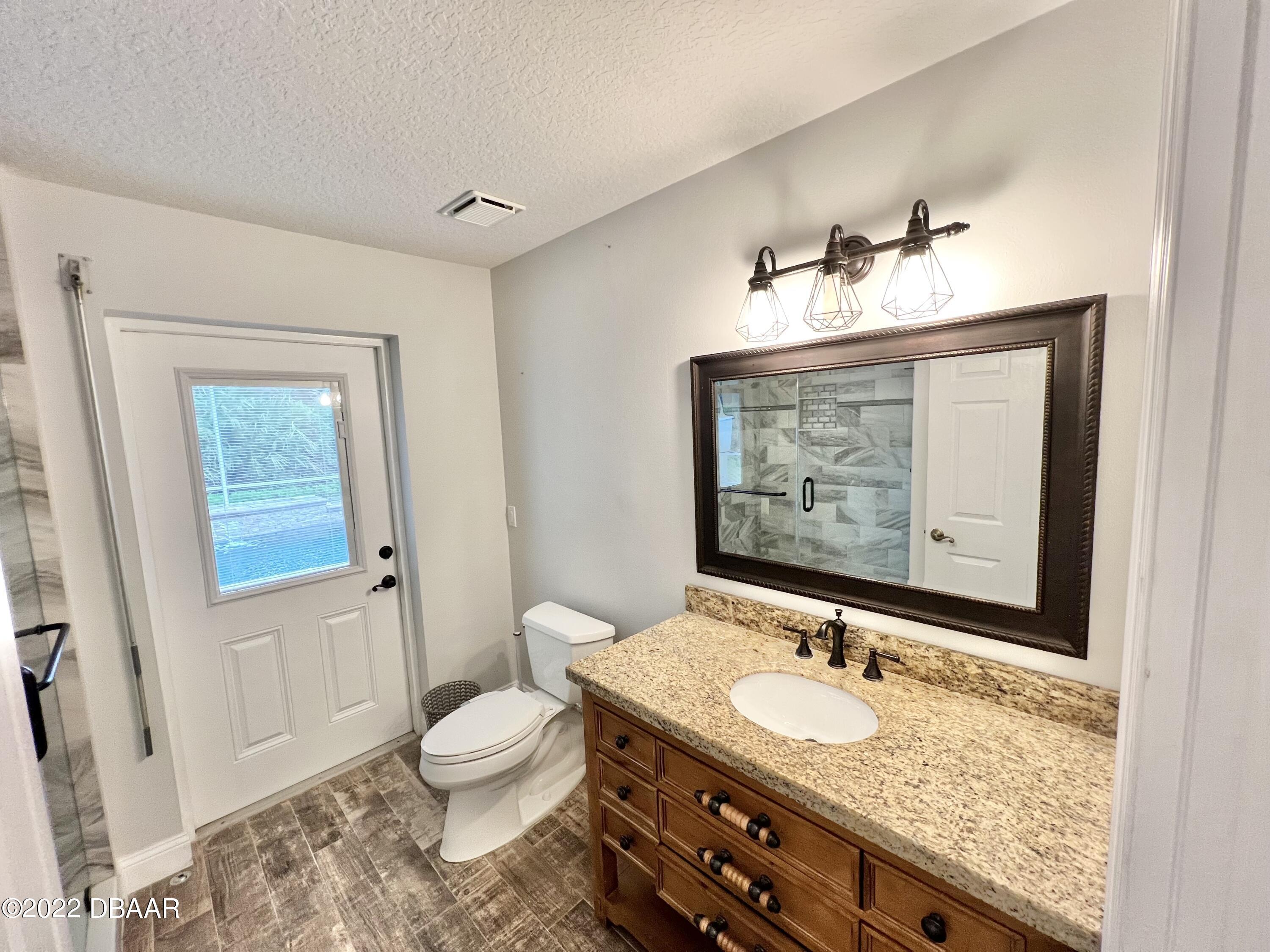 75 Creek Bluff Way Ormond Beach, FL 32174 - Photo 14 of 20 a bathroom with a granite countertop sink toilet and shower