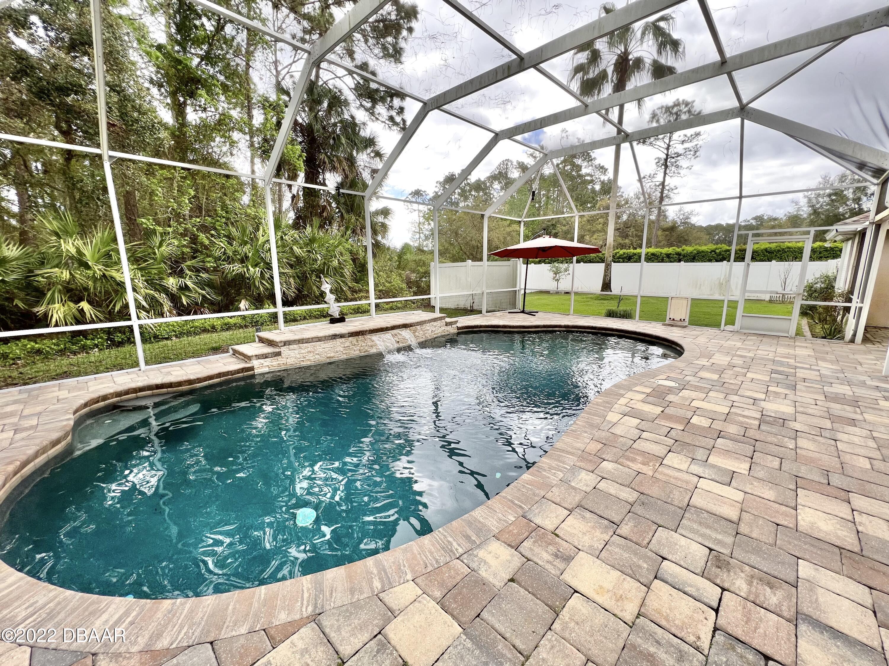 75 Creek Bluff Way Ormond Beach, FL 32174 - Photo 20 of 20 a view of a swimming pool with a yard and sitting area