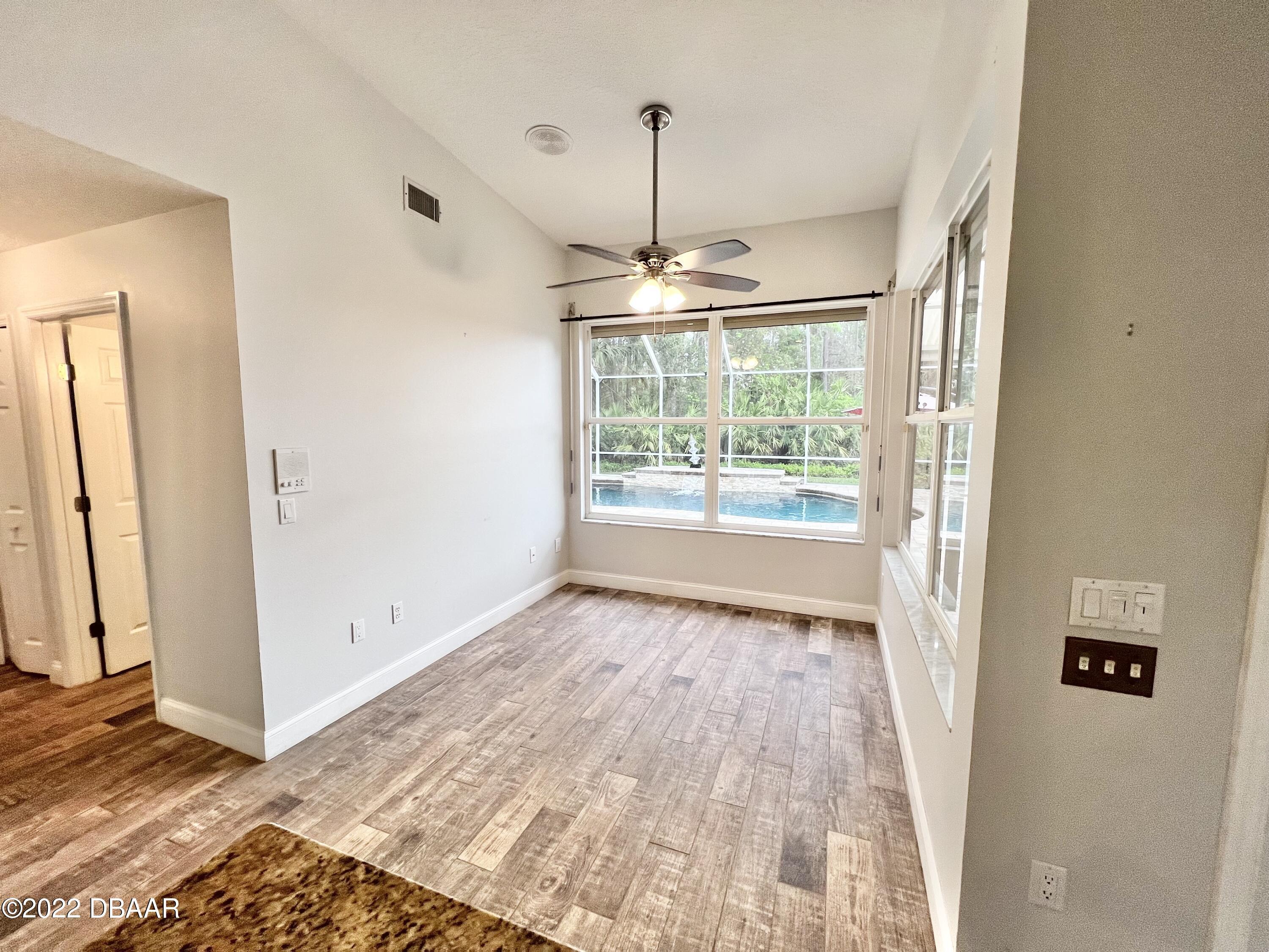 75 Creek Bluff Way Ormond Beach, FL 32174 - Photo 7 of 20 a view of empty room with wooden floor and fan