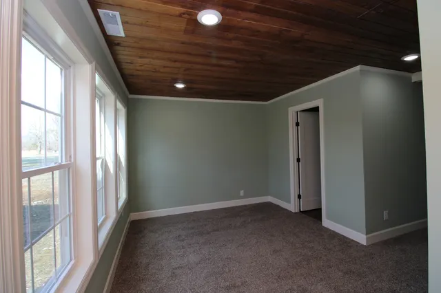 an empty room with wooden floor and a ceiling fan