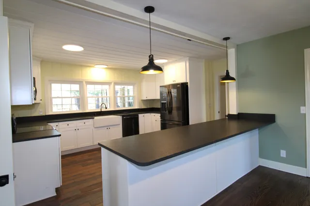 a kitchen with granite countertop a sink and a refrigerator