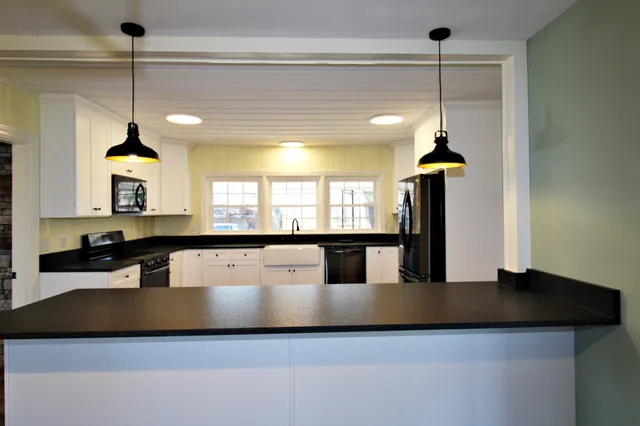 a kitchen with stainless steel appliances granite countertop a sink a stove and a refrigerator