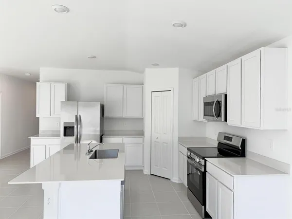 a kitchen with kitchen island a sink stove and refrigerator