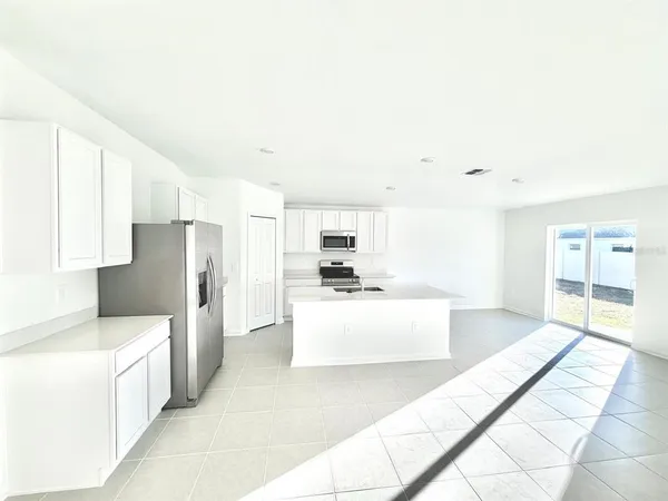 a large white kitchen with cabinets and stainless steel appliances