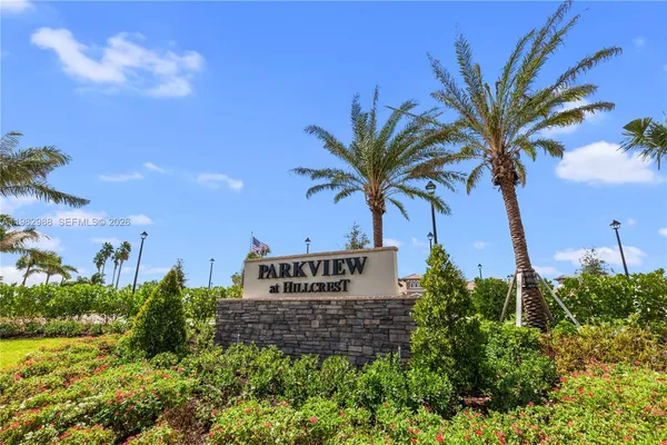 a view of a palm tree with sign in front of it
