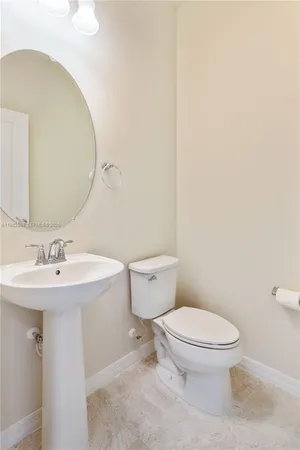 a bathroom with a toilet a sink and mirror