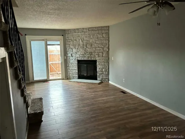 a view of a livingroom with a fireplace wooden floor and a window