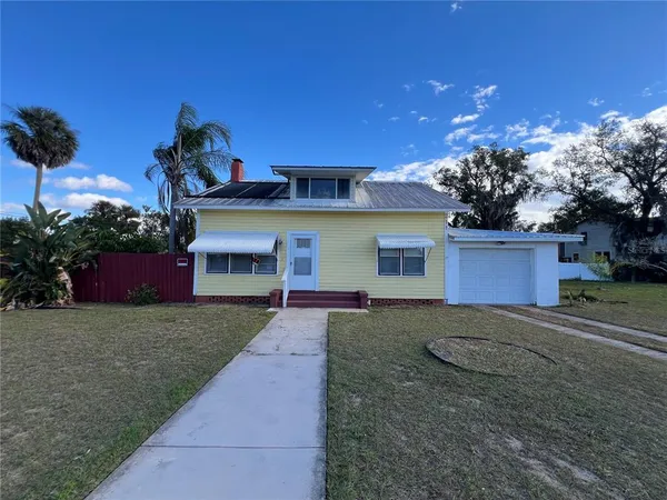 a front view of a house with a garden and yard