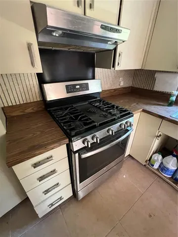 a stove top oven sitting inside of a kitchen
