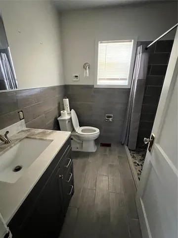 a bathroom with a sink and mirror with toilet