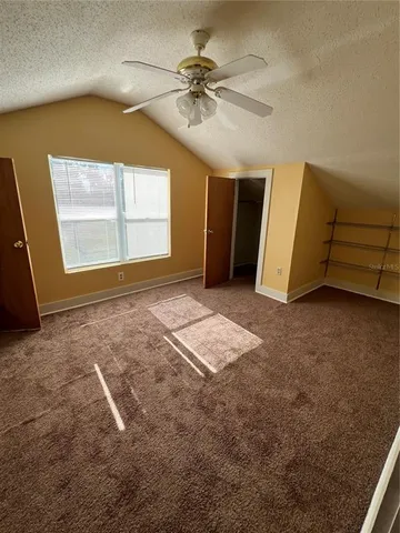 en empty room with windows and fan