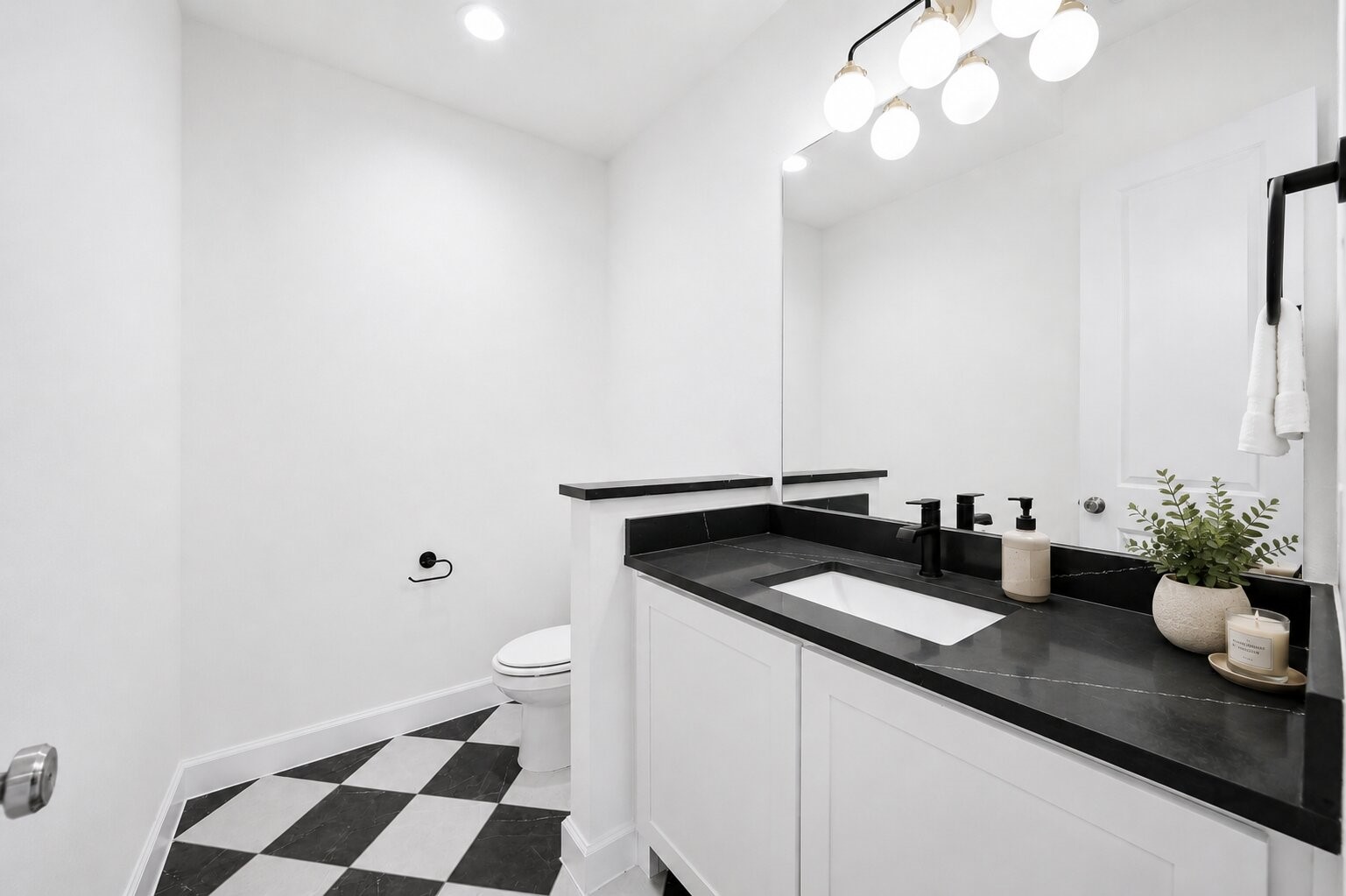 416 Venado View Court Conroe, TX 77304 - Photo 19 of 34 Designer-inspired powder room featuring striking black-and-white flooring, sleek quartz countertops, modern matte black fixtures, and clean contemporary finishes