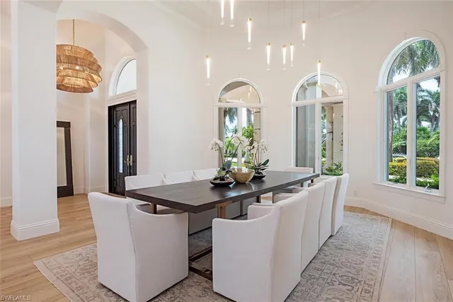 a dining room with kitchen island stainless steel appliances kitchen island furniture a large window and wooden floor
