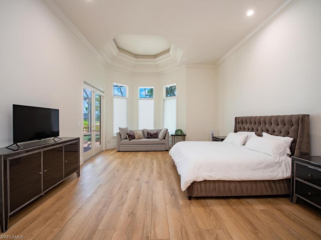 1633 China Berry Way Naples, FL 34105 - Photo 15 of 40 a bedroom with a bed and a flat screen tv