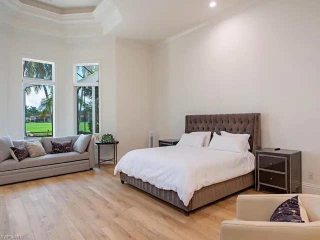 a bedroom with a bed a couch and a window