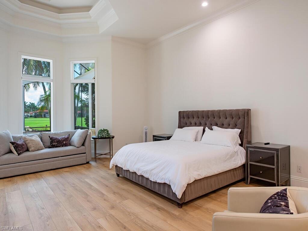 1633 China Berry Way Naples, FL 34105 - Photo 16 of 40 a bedroom with a bed a couch and a window
