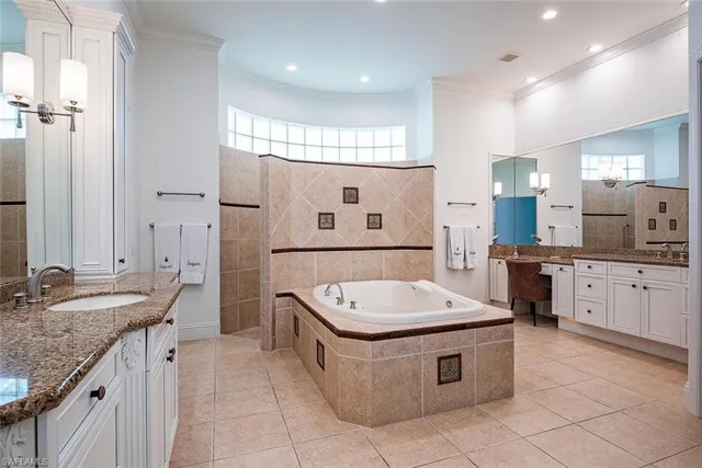 a bathroom with a granite countertop tub sink and mirror