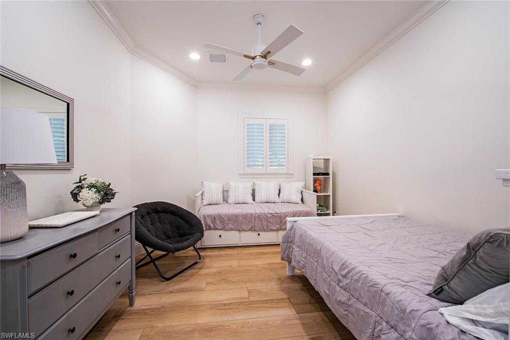 1633 China Berry Way Naples, FL 34105 - Photo 20 of 40 a bedroom with a bed and a chandelier