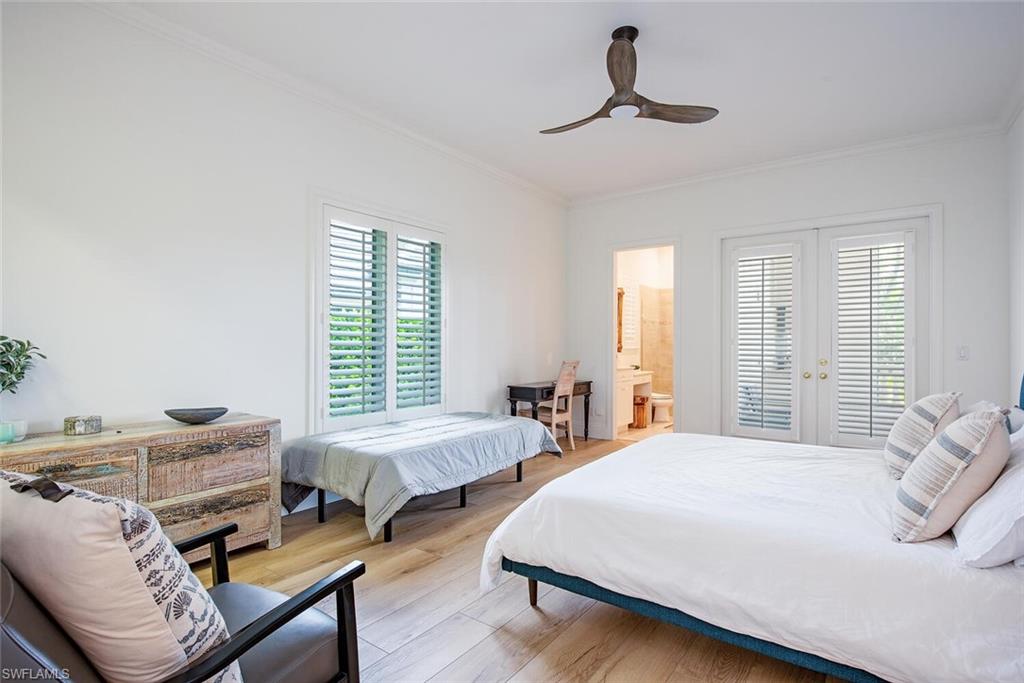 1633 China Berry Way Naples, FL 34105 - Photo 21 of 40 a bedroom with two beds and a chandelier