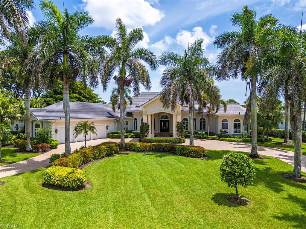 1633 China Berry Way Naples, FL 34105 - Photo 22 of 40 a front view of a house with a yard table and chairs