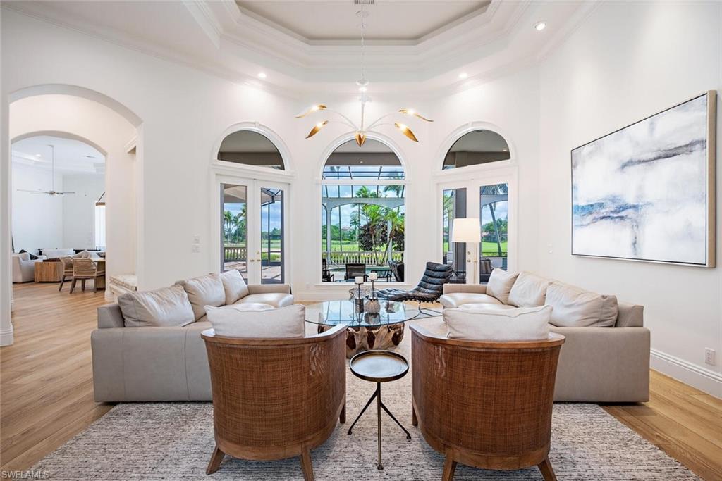 1633 China Berry Way Naples, FL 34105 - Photo 5 of 40 a living room with couches a dining table and chairs with wooden floor