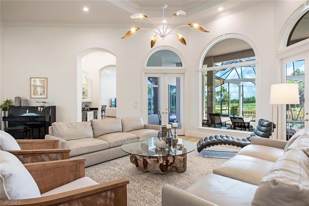 1633 China Berry Way Naples, FL 34105 - Photo 6 of 40 a living room with furniture a large window and a chandelier
