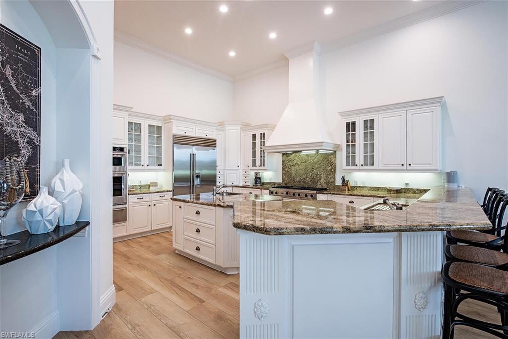 1633 China Berry Way Naples, FL 34105 - Photo 9 of 40 a kitchen with stainless steel appliances granite countertop a sink and cabinets