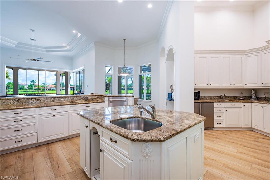 1633 China Berry Way Naples, FL 34105 - Photo 10 of 40 a kitchen with a sink stove and cabinets