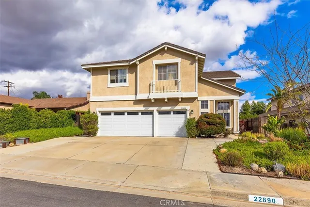 a front view of a house with a yard and potted plants
