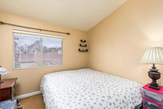 a bedroom with a bed and a lamp next to a window